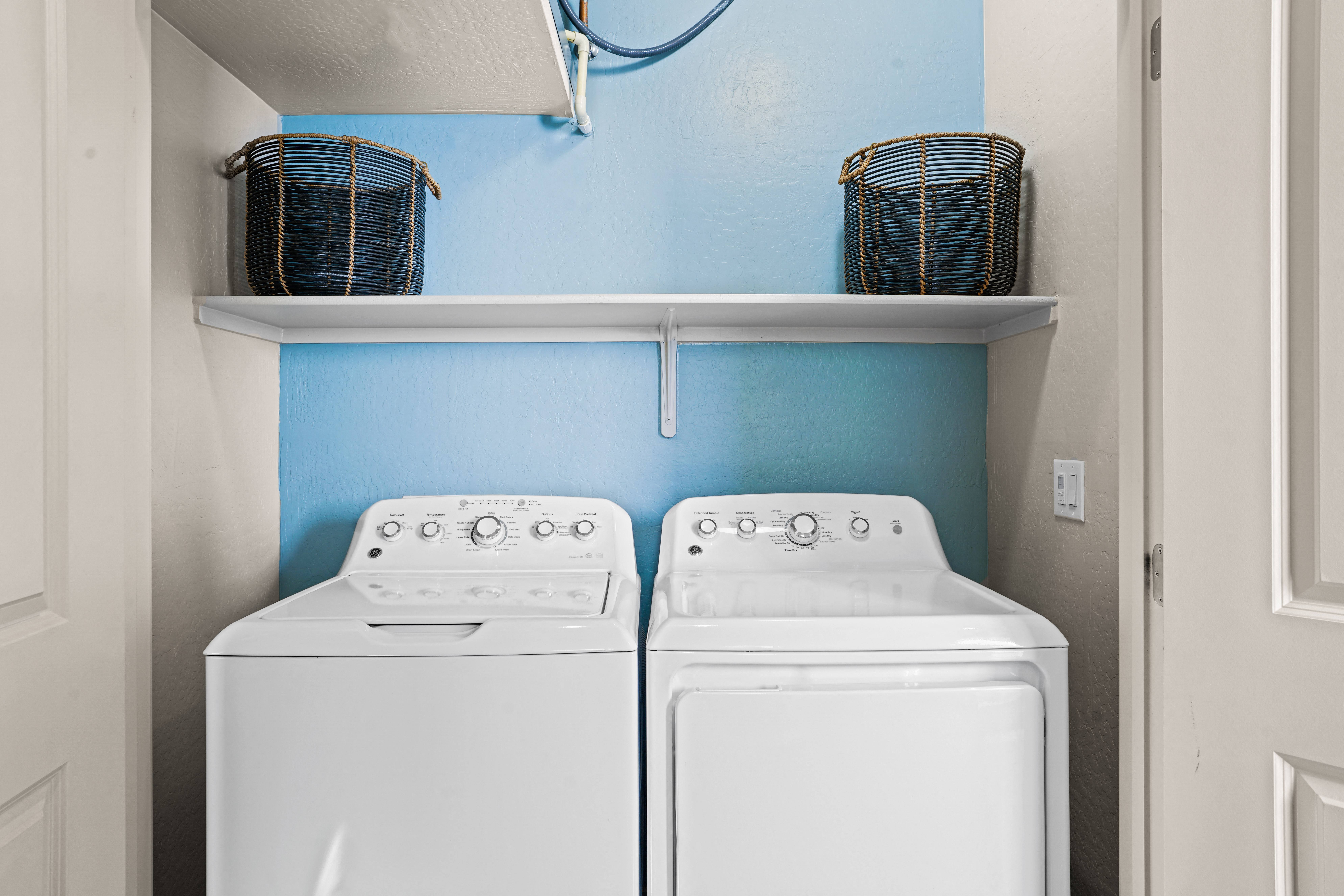 the washer and dryer in the laundry room of a house with blue walls at Olive Queen Creek Apartments, Queen Creek, AZ